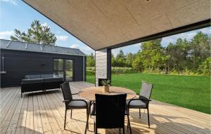 patio con tavolo e sedie su una terrazza di 4 Bedroom Stunning Home In Strandby a Strandby