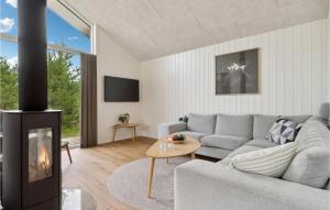 sala de estar con sofá y chimenea en 4 Bedroom Stunning Home In Strandby en Strandby