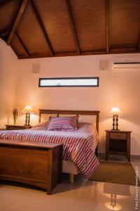 代曼的住宿－La Esquina - hermosa casa en Termas del Daymán，一间卧室配有一张床和两张台灯。