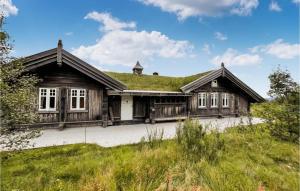 a large wooden house with a grass roof at Beautiful Home In stby With Wifi And 5 Bedrooms in Østby