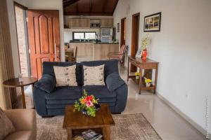 uma sala de estar com um sofá azul e uma mesa em La Esquina - hermosa casa en Termas del Daymán em Termas del Daymán