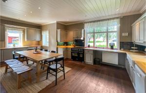 a kitchen with a wooden table and a wooden floor at Amazing Home In Koppang With Wifi And 8 Bedrooms in Koppang