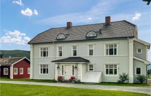 a large white house with a red house at Amazing Home In Koppang With Wifi And 8 Bedrooms in Koppang