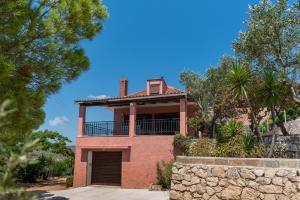 a red brick house with a balcony at Villa Apelati in Keri