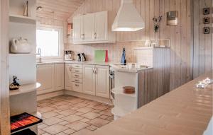 a kitchen with white cabinets and a counter top at 4 Bedroom Gorgeous Home In Hvide Sande in Havrvig