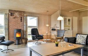 BjerregårdにあるPet Friendly Home In Hvide Sande With Kitchenの暖炉とレンガの壁が備わるリビングルーム