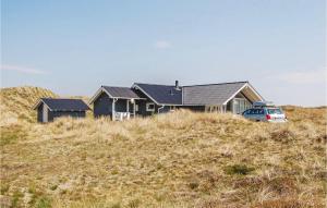 HavrvigにあるAwesome Home In Hvide Sande With 3 Bedrooms, Sauna And Wifiの車を持つ丘の上の家