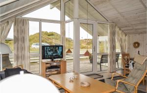 HavrvigにあるAwesome Home In Hvide Sande With 3 Bedrooms, Sauna And Wifiのリビングルーム(テレビ、テーブル付)