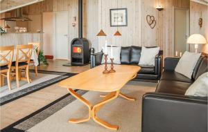 a living room with a table and a wood stove at Nice Home In Hvide Sande With Kitchen in Havrvig