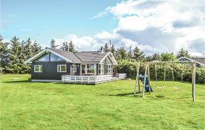 a small house with a playground in a yard at 4 Bedroom Cozy Home In Hvide Sande in Havrvig