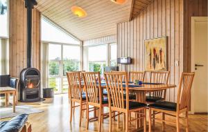 a dining room with a table and chairs and a wood stove at 4 Bedroom Cozy Home In Hvide Sande in Havrvig