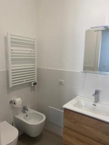 ein Badezimmer mit Waschbecken, Toilette und Spiegel in der Unterkunft Villa Popilia Sea&Business Blue in Rimini + 42 Fotos