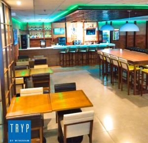 a restaurant with tables and chairs and a bar at TRYP BY WYNDHAM São Paulo Airport - Hotel de Transito Terminal 3 INTERNACIONAL - Lado Ar - Área restrita á passageiros já embarcados e sem bagagens para despachar - Transit Hotel, only carry-on in Guarulhos