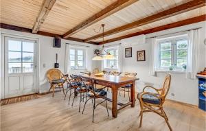 BjerregårdにあるAmazing Home In Hvide Sande With Wifiのダイニングルーム(木製テーブル、椅子付)