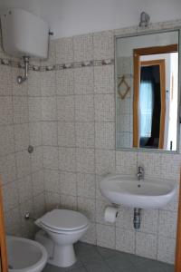 a bathroom with a toilet and a sink and a mirror at La collina degli ulivi in Conocchia