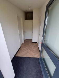 een lege kamer met een gang met een deur bij De Platwever 3B in Zelhem