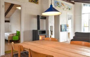 a dining room with a table and a fireplace at 4 Bedroom Beach Front Home In Hvide Sande in Bjerregård