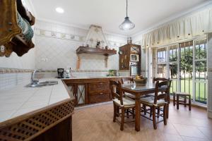a kitchen with a table and chairs and a sink at Villa Juani in Chiclana de la Frontera