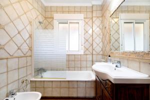 a bathroom with two sinks and a tub and a mirror at Villa Juani in Chiclana de la Frontera +20 photos