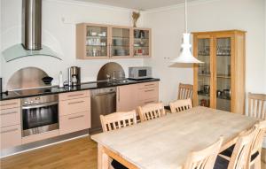 スケーエンにあるAwesome Home In Skagen With Kitchenのキッチン(木製テーブル、椅子付)