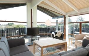 sala de estar con sofás y TV en el balcón en Beautiful Home In Hjrring With House Sea View, en Lønstrup
