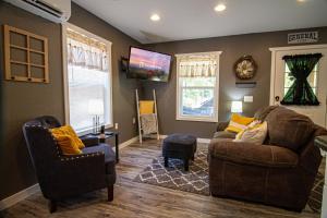 sala de estar con 2 sofás y TV en Mountain Haven Dragon's Nest Cabin, en Robbinsville