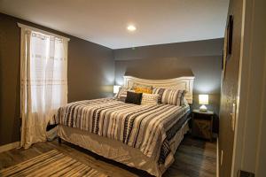 a bedroom with a bed with a striped comforter at Mountain Haven Dragon's Nest Cabin in Robbinsville