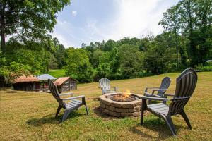 a group of three chairs sitting around a fire pit at Mountain Haven Dragon's Nest Cabin in Robbinsville