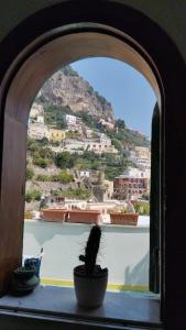 una maceta sentada en el alféizar de una ventana con una montaña en My Way, en Positano
