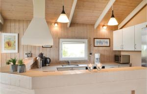 ヴィデ・サンデにある3 Bedroom Awesome Home In Hvide Sandeの白いキャビネットとキッチンアイランド付きのキッチン
