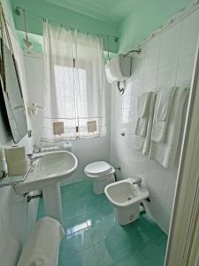 a white bathroom with a sink and a toilet at Casale Villa Rainò in Gangi