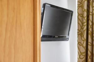 un televisor colgado en una pared junto a una puerta en Properties Unique Dene Rooms Twin en Newcastle