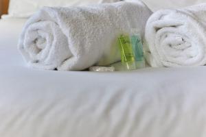 une pile de serviettes et de dentifrice sur un lit dans l'établissement Properties Unique Dene Rooms Twin, à Newcastle upon Tyne