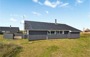 Havrvig的住宿－Stunning Home In Hvide Sande With Kitchen，黑色房子,有黑色屋顶