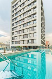 una piscina de hotel con un edificio de fondo en Apto com incrivel localizacao em Porto Alegre SP, en Porto Alegre