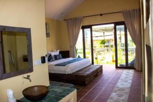 a bedroom with a bed and a bathroom with a mirror at Kampot Eco Village in Kampot