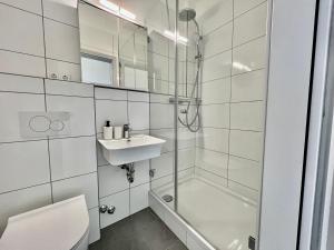 een badkamer met een douche, een wastafel en een toilet bij Trippel M Apartments Stuttgart Zuffenhausen in Stuttgart