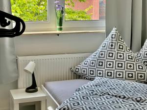 a bedroom with a bed with a pillow and a window at Trippel M Apartments Stuttgart Zuffenhausen in Stuttgart