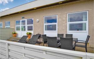 a deck with chairs and a table on a building at 2 Bedroom Gorgeous Home In Hvide Sande in Havrvig