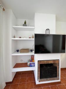 sala de estar con chimenea y TV de pantalla plana en AP21-Sa Riera en Begur