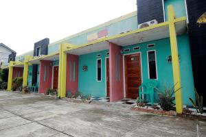 a row of colorful houses in a parking lot at OYO 2362 Wisma Ria in Lubuklinggau