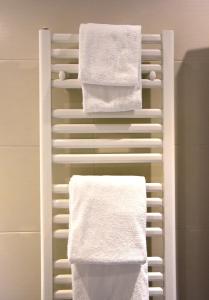 a towel rack with white towels on it in a bathroom at Hotel y Apartamentos SNÖ Isaba in Isaba