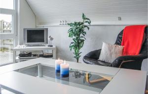 Bjerregårdにある3 Bedroom Cozy Home In Hvide Sandeのリビングルーム(テーブル、テレビ、キャンドル2本付)