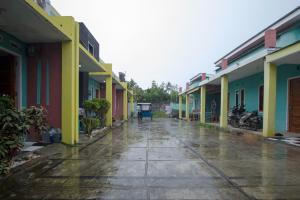 an empty street with colorful buildings in the rain at OYO 2362 Wisma Ria in Lubuklinggau
