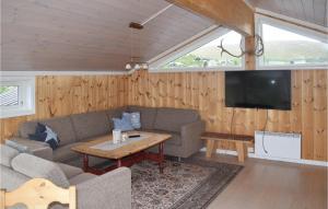 a living room with a couch and a table and a tv at Amazing Home In Eggedal With Sauna And 6 Bedrooms in Eggedal