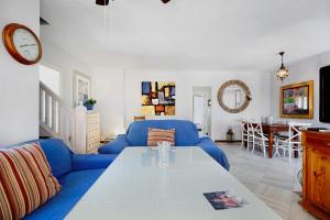 ein Wohnzimmer mit einem blauen Sofa und einem Tisch in der Unterkunft Magnifico piso en la playa in El Puerto de Santa María
