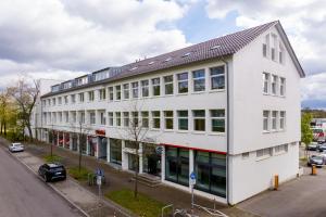 ein großes weißes Gebäude mit Fenstern auf einer Straße in der Unterkunft mk hotel stuttgart in Stuttgart