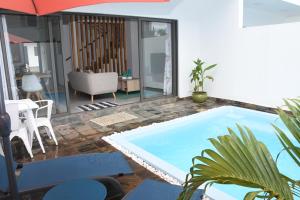 een zwembad in een woonkamer met een parasol bij la falaise paradis Mauritius in Flic-en-Flac