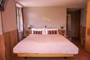 sypialnia z dużym łóżkiem z białą pościelą w obiekcie Gasthof zur Bündte w mieście Jenins
