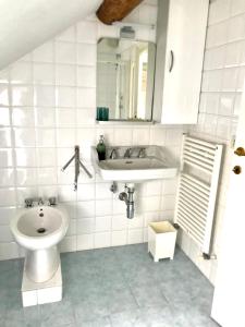 uma casa de banho branca com um lavatório e um WC em Casa Gaia em Albissola Marina